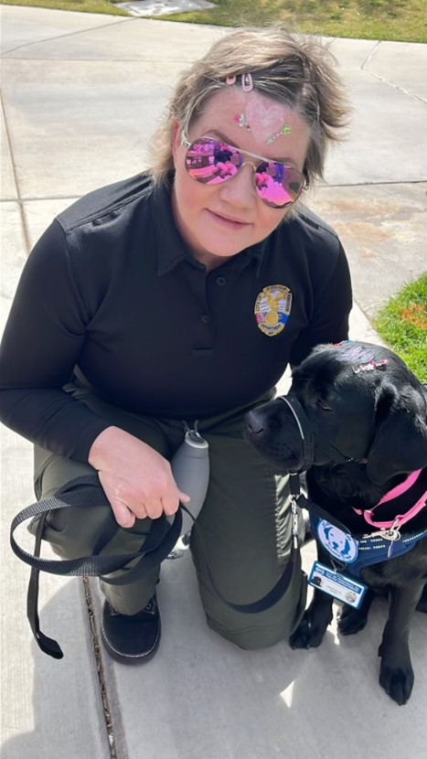 An Image of the Henderson Police Department's Community Engagement Dog Jinx with her Handler Officer Katrina Farrell