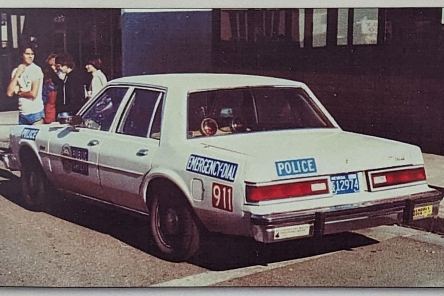An Old Close Up Shot Image in Sepia of the Henderson Police Department Car with the 911 at the Rear in the 1980s